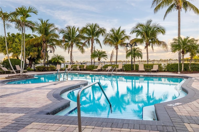 pool at dusk featuring a patio