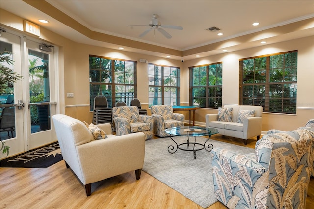 living room with light hardwood / wood-style floors, ornamental molding, and ceiling fan