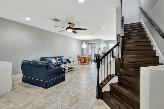 living room featuring ceiling fan with notable chandelier