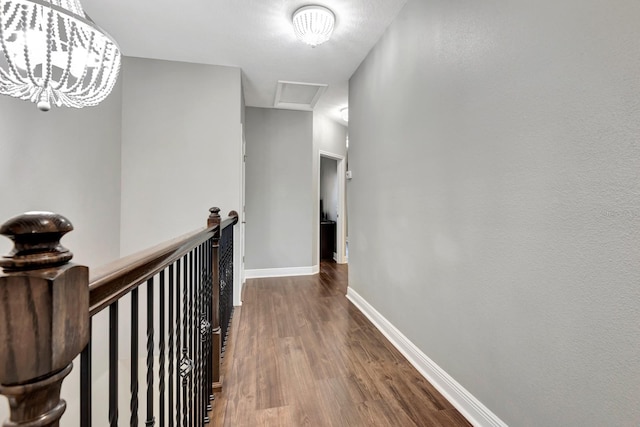 corridor featuring hardwood / wood-style flooring and an inviting chandelier