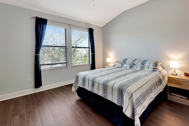 bedroom with vaulted ceiling and dark hardwood / wood-style flooring