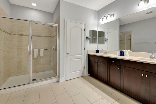 bathroom featuring vanity, a shower with shower door, and tile patterned flooring