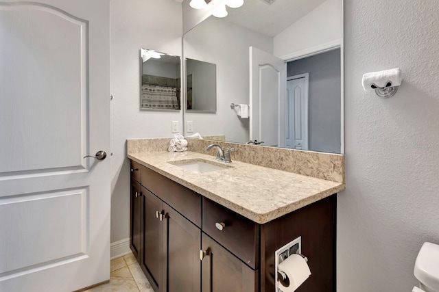 bathroom featuring vanity, toilet, and tile patterned floors