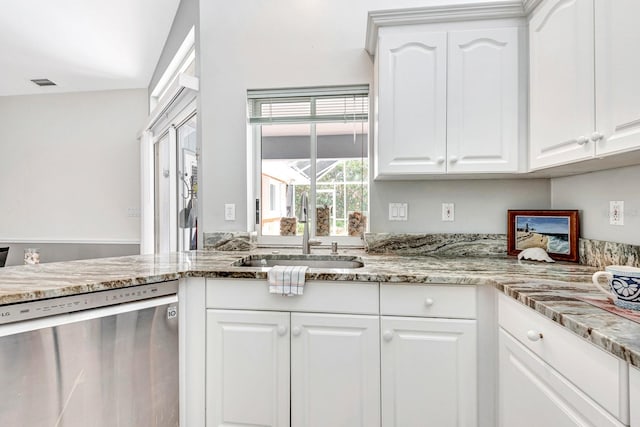 kitchen featuring stainless steel dishwasher, vaulted ceiling, sink, white cabinetry, and light stone countertops