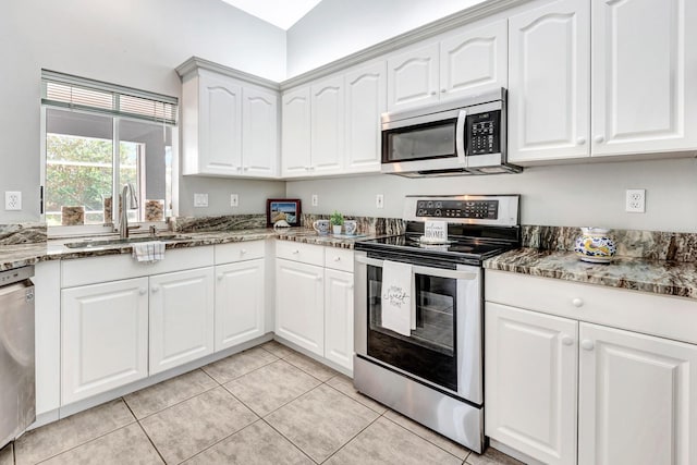 kitchen with sink, dark stone countertops, white cabinetry, and appliances with stainless steel finishes