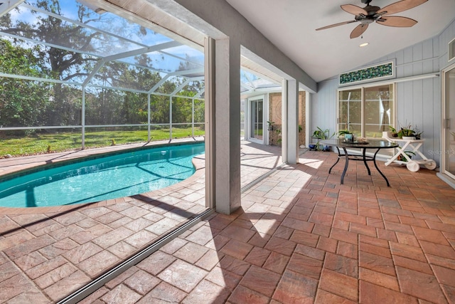 view of pool with glass enclosure, ceiling fan, and a patio