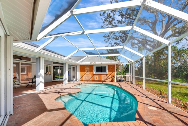 view of swimming pool featuring a lanai and a patio