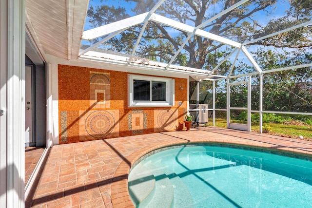 view of swimming pool with a lanai, cooling unit, and a patio