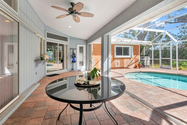 view of pool featuring glass enclosure, central AC unit, a patio, and ceiling fan