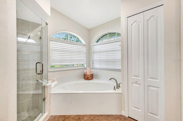 bathroom featuring tile patterned flooring, vaulted ceiling, and shower with separate bathtub