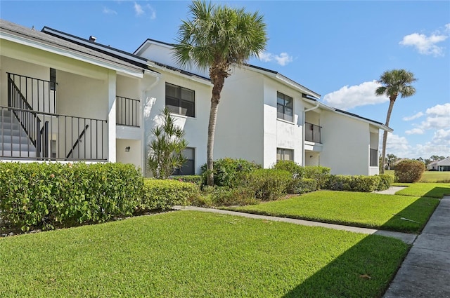 exterior space with a yard and a balcony