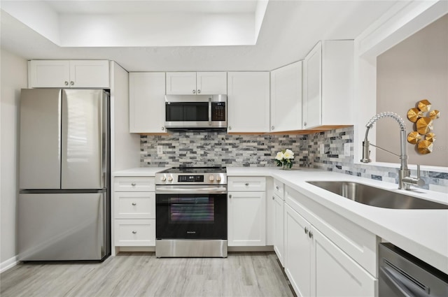 kitchen with white cabinetry, light hardwood / wood-style flooring, stainless steel appliances, and sink