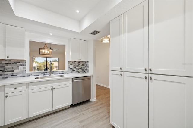 kitchen featuring white cabinets, tasteful backsplash, stainless steel dishwasher, light hardwood / wood-style flooring, and sink