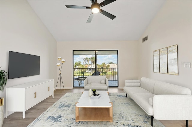 living room with hardwood / wood-style floors, high vaulted ceiling, and ceiling fan