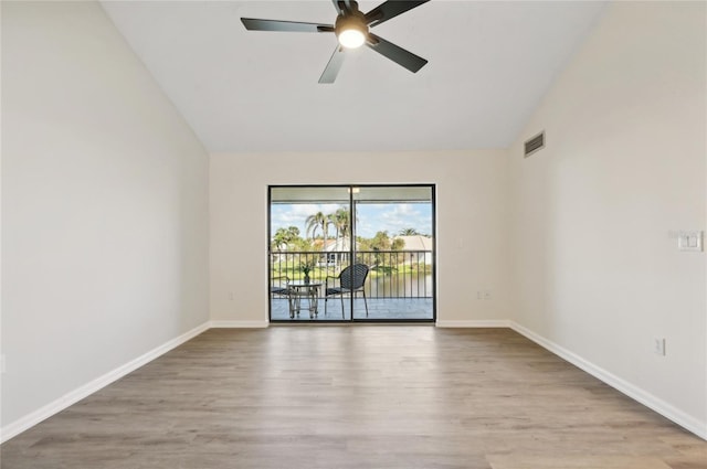 empty room featuring light hardwood / wood-style flooring, ceiling fan, and vaulted ceiling