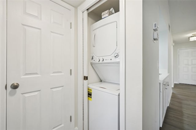 washroom with dark hardwood / wood-style floors and stacked washer and dryer