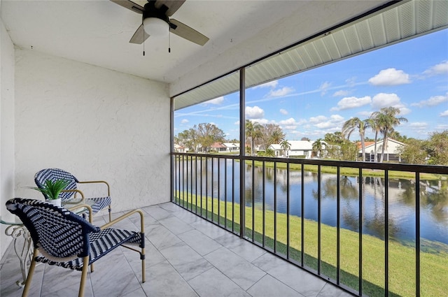 sunroom / solarium featuring a water view and ceiling fan