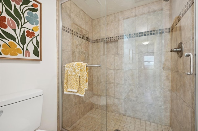 bathroom featuring toilet and a shower with door