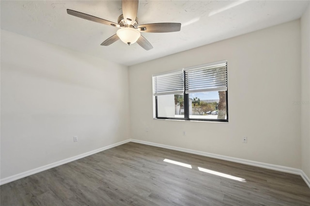 unfurnished room featuring dark wood-type flooring and ceiling fan