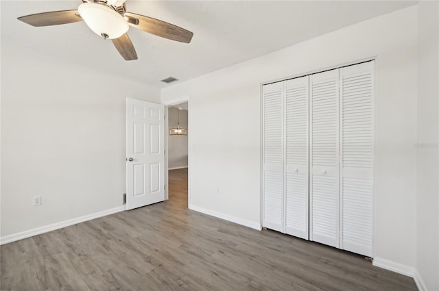 unfurnished bedroom with hardwood / wood-style floors, a closet, and ceiling fan