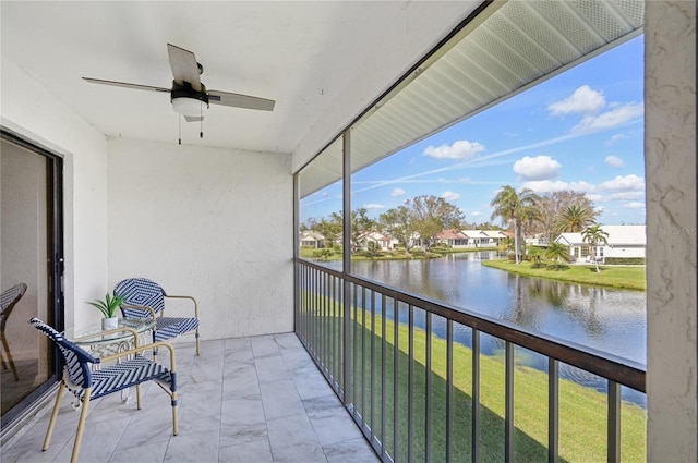 balcony with a water view and ceiling fan