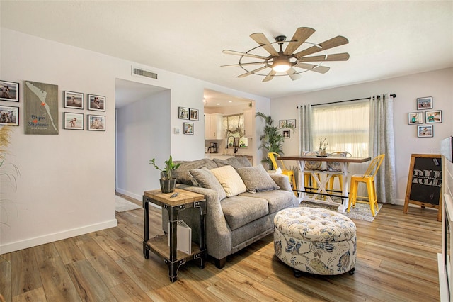 living room featuring light wood-type flooring and ceiling fan