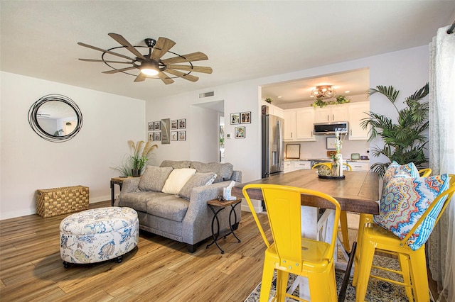 dining area with light hardwood / wood-style flooring and ceiling fan