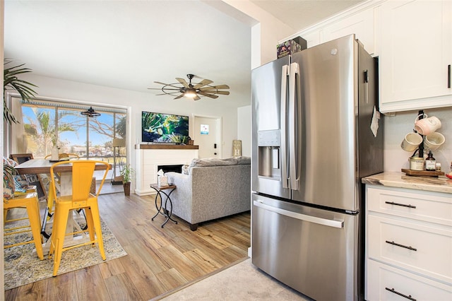 kitchen featuring white cabinetry, light hardwood / wood-style flooring, stainless steel fridge, and ceiling fan