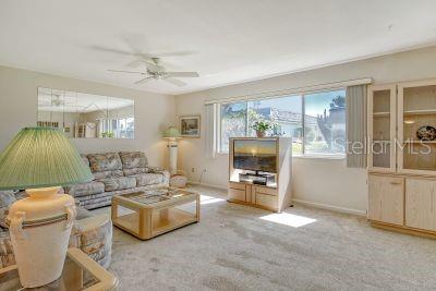 carpeted living room featuring ceiling fan