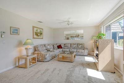 living room featuring light colored carpet and ceiling fan