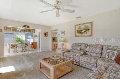 carpeted living room featuring ceiling fan