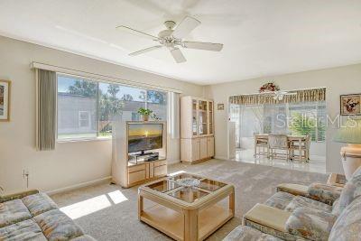 carpeted living room with ceiling fan