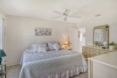 bedroom featuring light carpet and ceiling fan