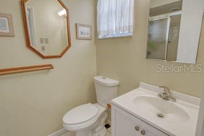 bathroom featuring vanity, toilet, and walk in shower