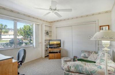 carpeted office space with ceiling fan