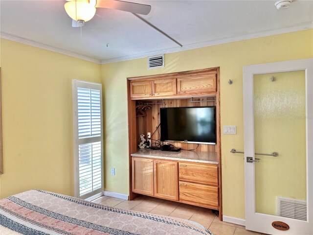 bedroom with light tile patterned floors, visible vents, ceiling fan, and ornamental molding