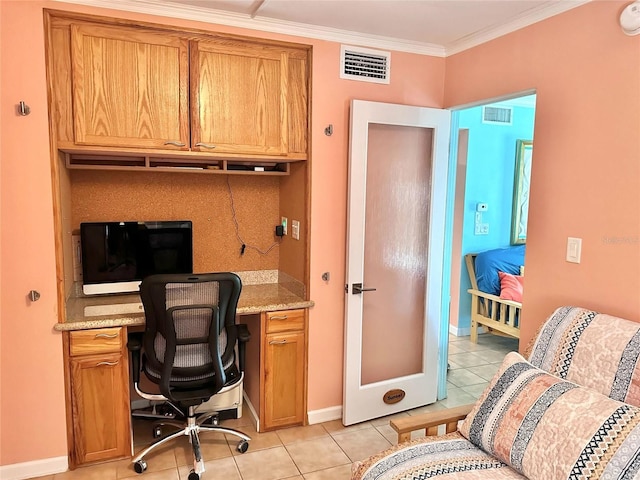 home office with light tile patterned floors, visible vents, baseboards, built in desk, and ornamental molding