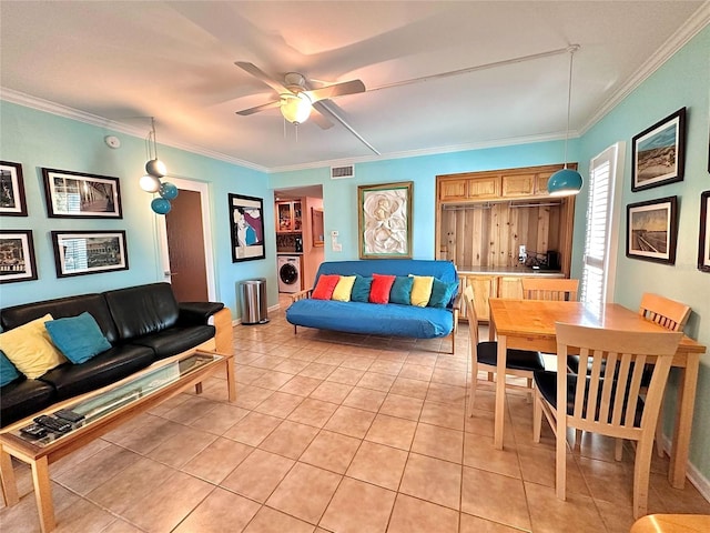 living area with visible vents, crown molding, light tile patterned floors, and washer / clothes dryer