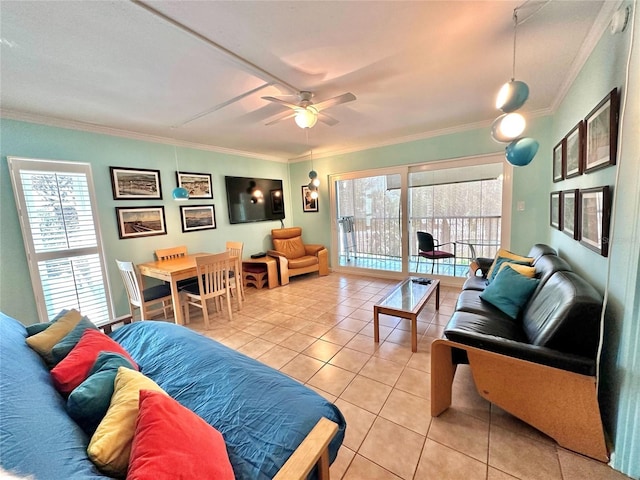 living area with a ceiling fan, a healthy amount of sunlight, ornamental molding, and light tile patterned flooring