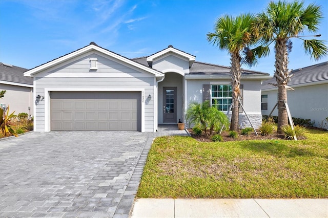 ranch-style home featuring a front lawn and a garage