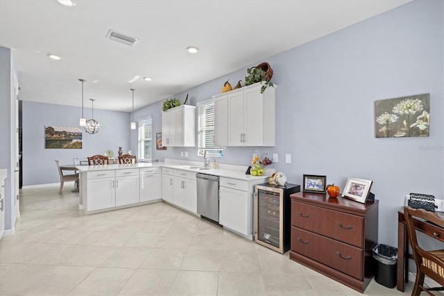 kitchen with pendant lighting, kitchen peninsula, stainless steel dishwasher, and white cabinets