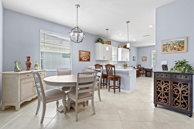 dining space featuring a notable chandelier, a healthy amount of sunlight, and light tile patterned floors