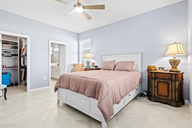 tiled bedroom featuring a closet, a spacious closet, connected bathroom, and ceiling fan