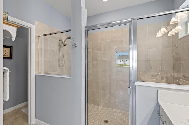 bathroom featuring vanity, a shower with shower door, and tile patterned flooring