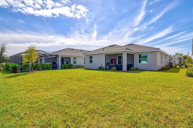 back of house featuring a lawn and a lanai