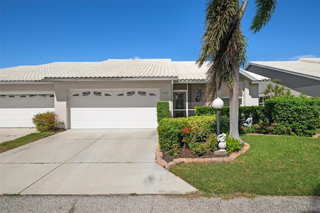 single story home featuring a front lawn and a garage