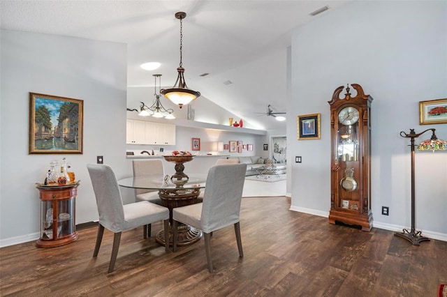 dining area with dark wood-type flooring, high vaulted ceiling, and ceiling fan with notable chandelier