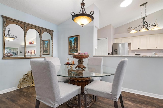 dining room with lofted ceiling, a notable chandelier, and dark wood-type flooring