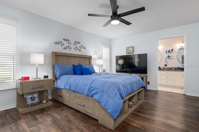 bedroom featuring ensuite bath, a textured ceiling, dark hardwood / wood-style floors, and ceiling fan