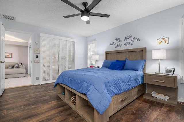 bedroom featuring ceiling fan, a textured ceiling, and dark hardwood / wood-style flooring